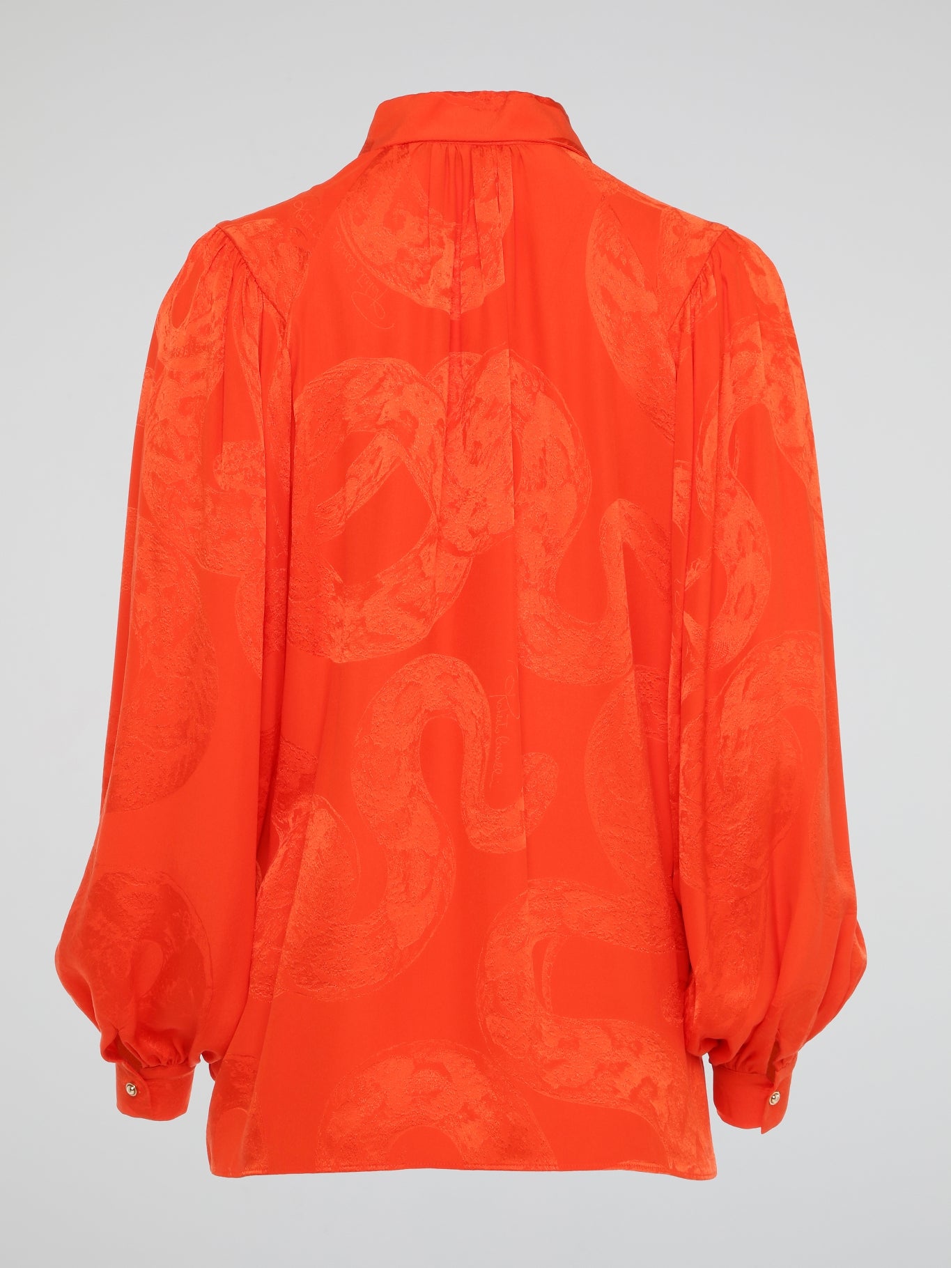 Unleash your wild side with this striking Orange Snake Print Blouse from the iconic Roberto Cavalli. Crafted with luxurious silk fabric, this statement piece features a bold snake print pattern that is sure to turn heads wherever you go. Embrace your inner fashionista and make a fierce style statement with this must-have addition to your wardrobe.