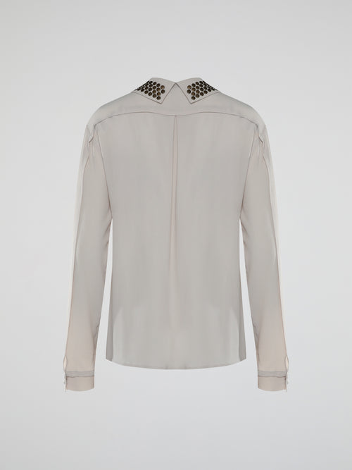 Indulge in the perfect blend of elegance and edginess with the Beige Studded Collar Blouse from Roberto Cavalli. Crafted with meticulous attention to detail, this unique blouse features a beautifully adorned studded collar that adds a daring touch to a classic silhouette. Whether it's a formal event or a night out on the town, this statement piece will effortlessly elevate any ensemble and make heads turn your way.