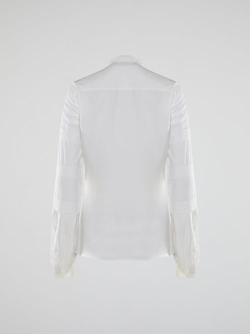 Step into the world of timeless elegance with the White Pleated Bib Shirt from Roberto Cavalli. Crafted with meticulous attention to detail, this masterpiece combines effortless sophistication with a touch of whimsical charm. From its delicate pleated bib to its crisp white fabric, this shirt will make a statement in any setting, exuding refined elegance that is truly captivating.