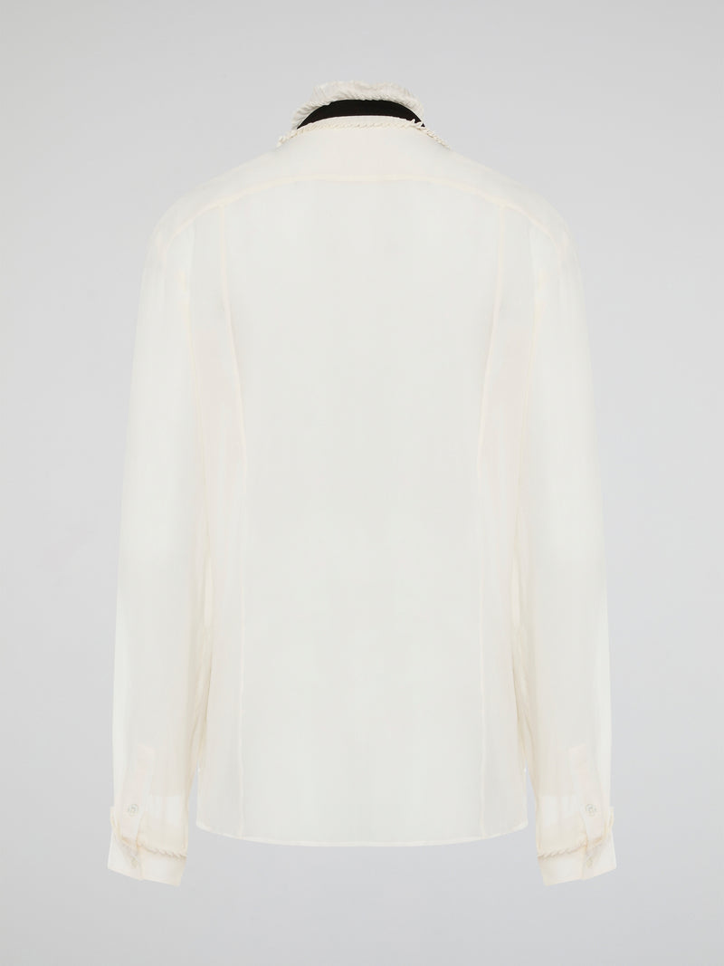 Step into luxury and sophistication with the Roberto Cavalli White Frill Detailed Blouse. The delicate frill detailing adds a touch of elegance to this classic white blouse, making it a perfect choice for any special occasion. Elevate your wardrobe with this timeless piece that exudes high-end fashion and style.